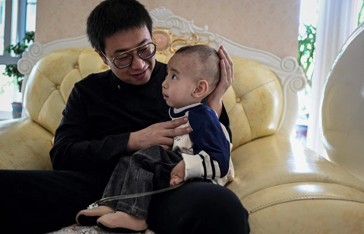 Mr Xu holding his infant son.