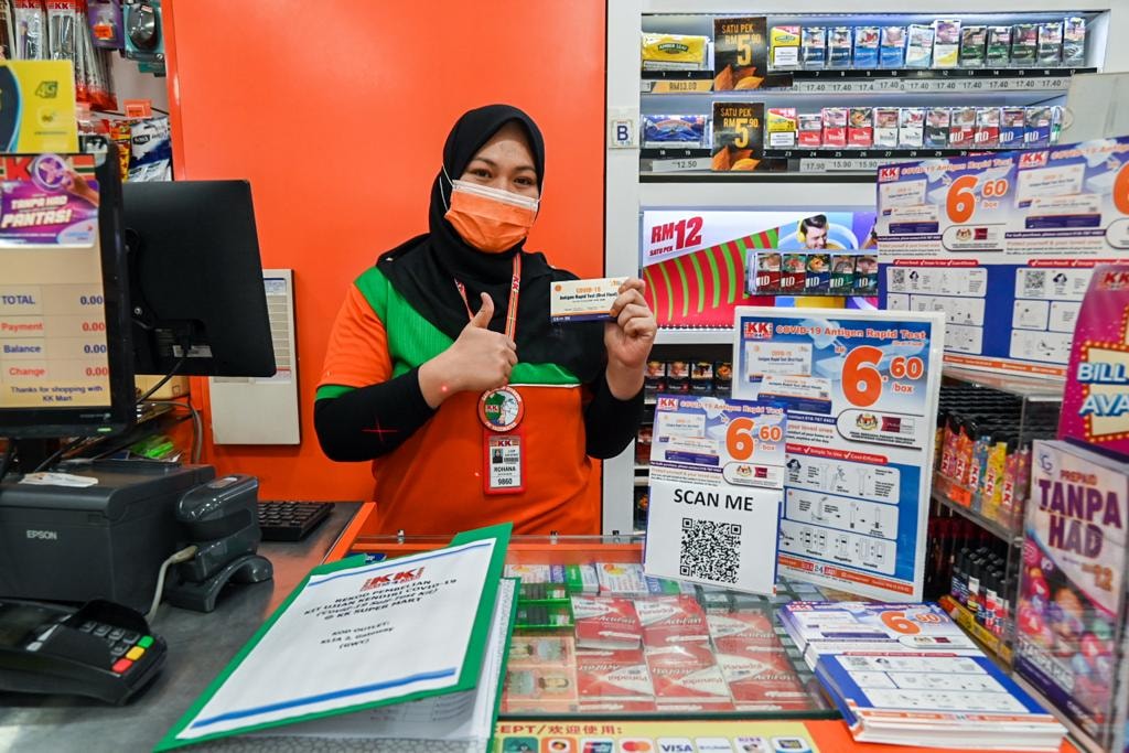A cashier showing the test kit for sale.