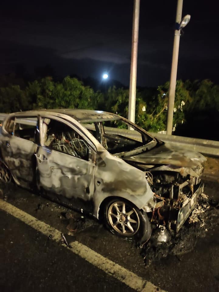 The wreckage of the Perodua Axia after the flames have been extinguished.