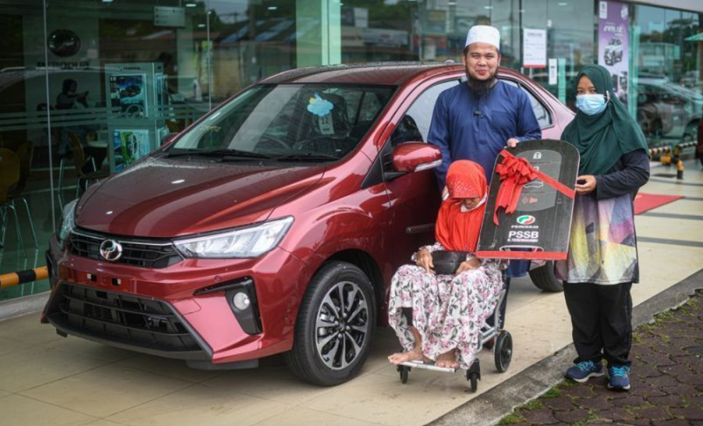 The woman, who is an ice-cream seller, stands next to her brand-new Perodua Bezza gifted to her by Ebit Lew. Source: @ebitlew