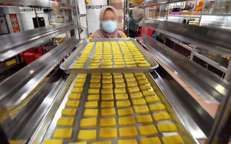 A woman preparing crackers in a factory.