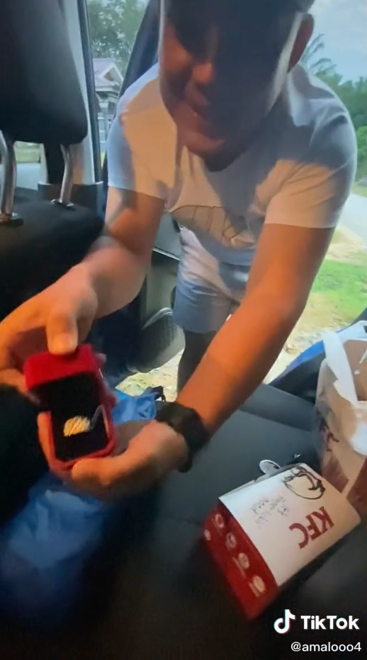 Akmal showing the ring he bought as a gift to be placed in a KFC meal box.