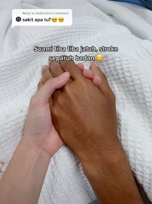 Syazwani holding on to her husband's hand after he had been hospitalised.