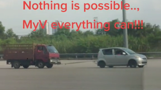 MyVi seen towing a broken-down truck.