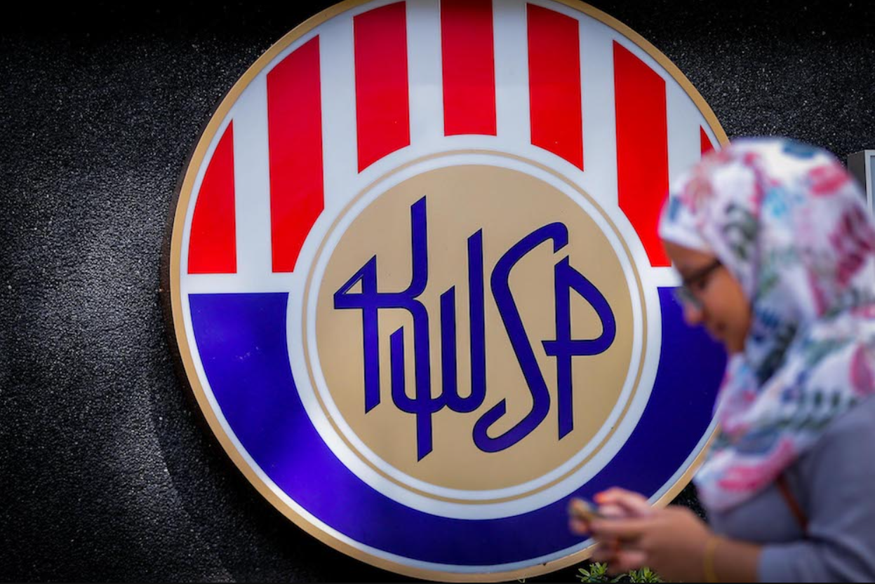 A woman walks past the logo of the EPF building.