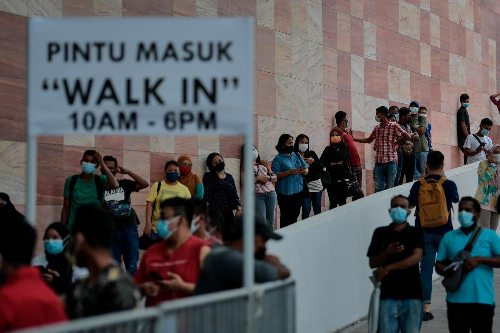 People walking into a vaccination centre for their walk-in appointments in Malaysia. 