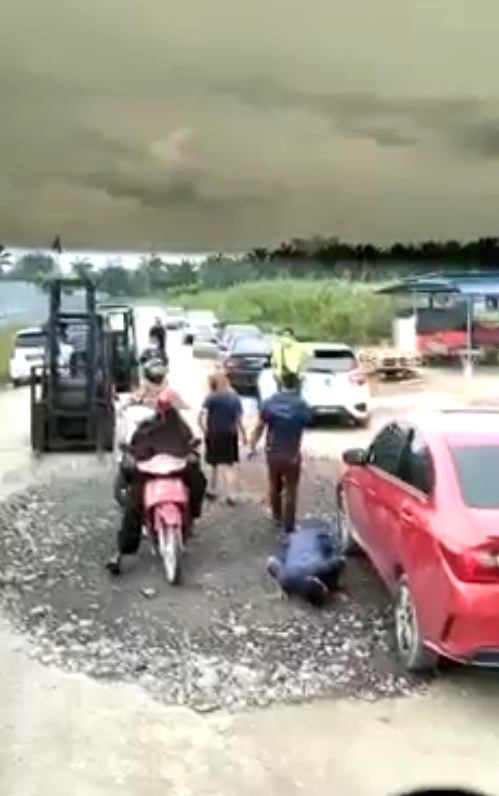 The illegally parked car being moved away by a forklift.