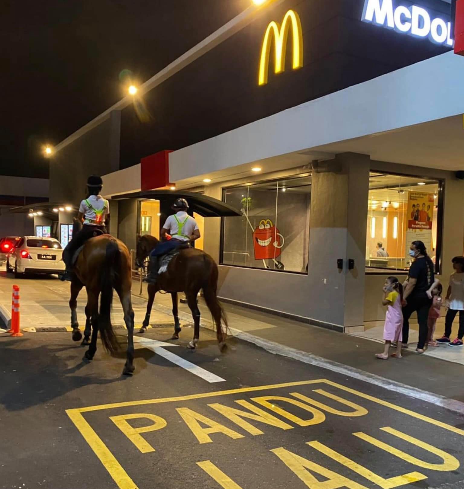 Horses along a McDonald's drive-thru.