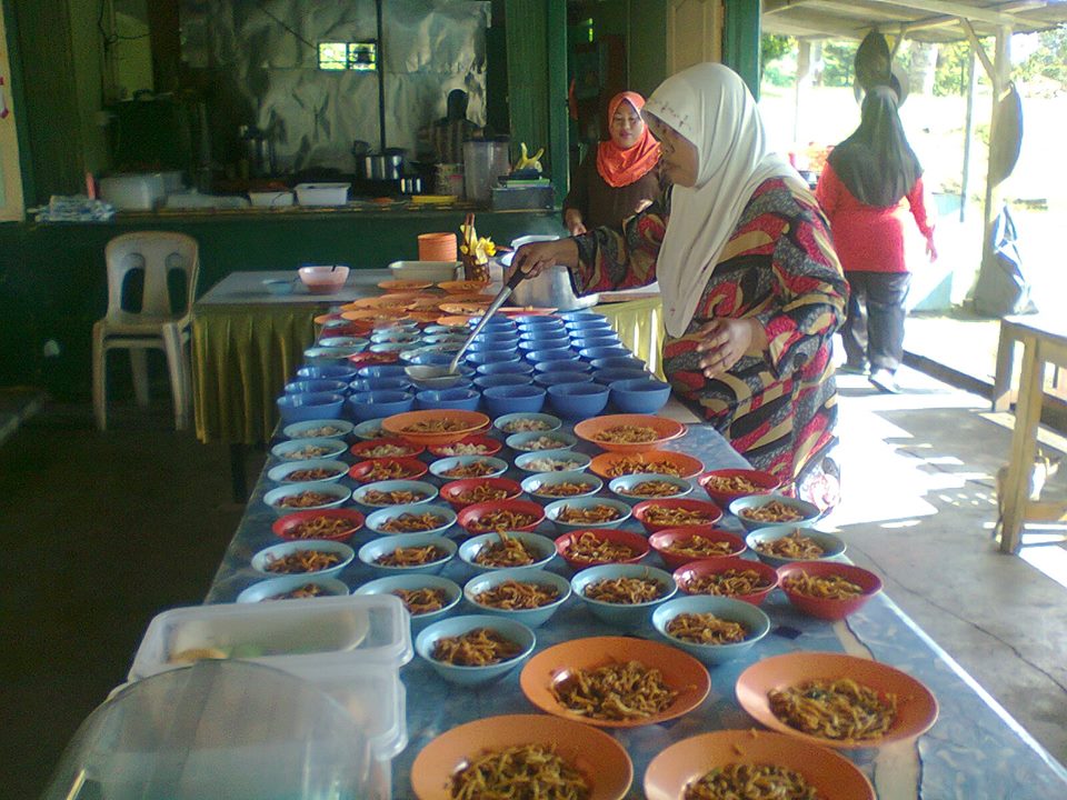 A canteen helper distributing free meals.