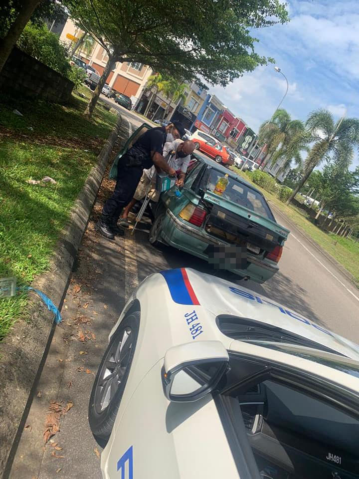 The kind abang polis lending a hand to an elderly OKU uncle.