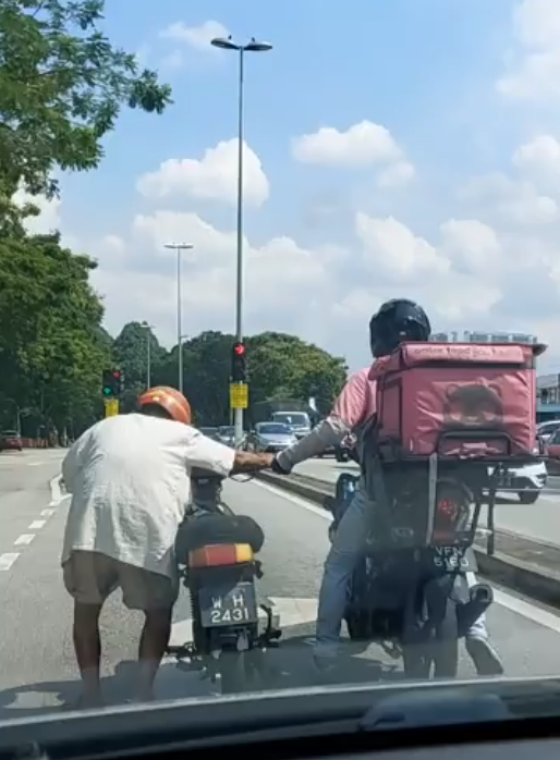 A food delivery rider helping out an elderly man.