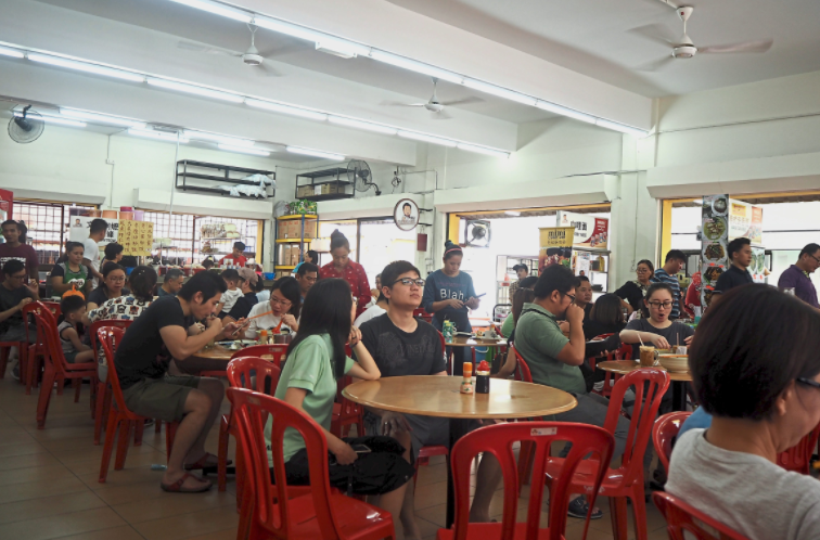 Patrons waiting to be seated at a kopitiam.