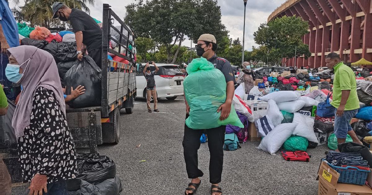 A volunteer helping to move donations around the stadium carpark.