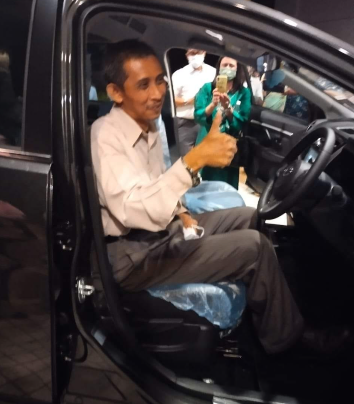 Mr Ahmad being presented with his new car by his students.