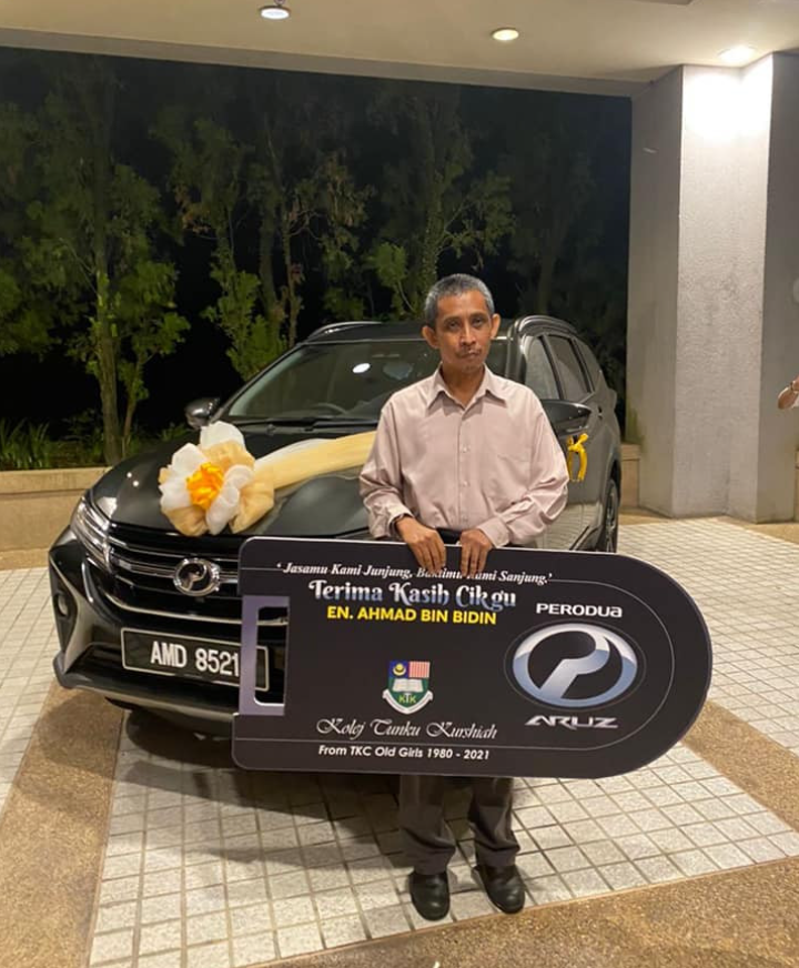 Mr Ahmad being presented with his new car by his students.