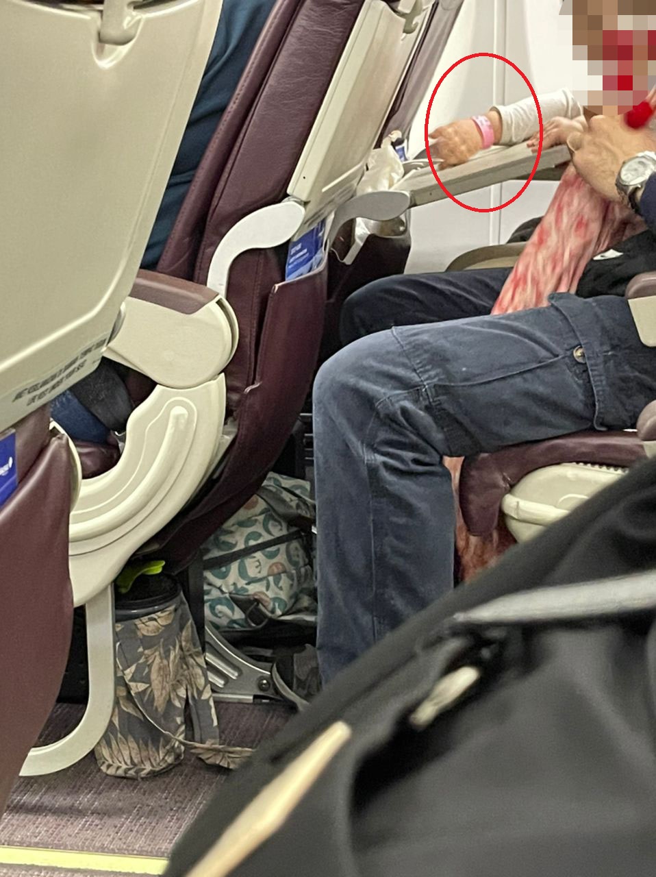 A passenger seen wearing a pink quarantine wristband on board a Malaysia Airlines flight.