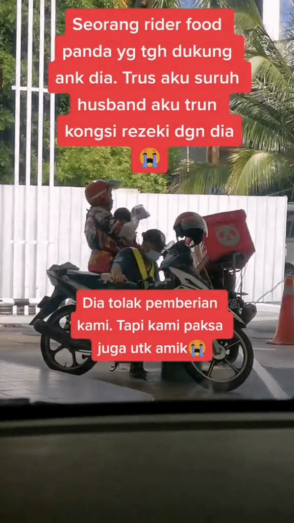 The woman working as a food delivery rider can be seen carrying her own baby at a petrol station.