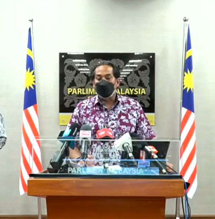 A photo of Khairy Jamaluddin discussing the spread of the Omicron variant in Malaysia.