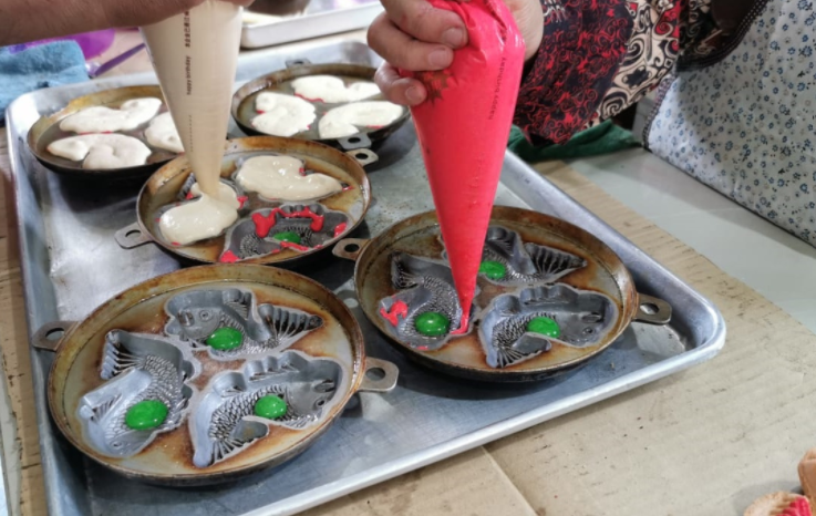 Pujiah preparing the cakes in their moulds.