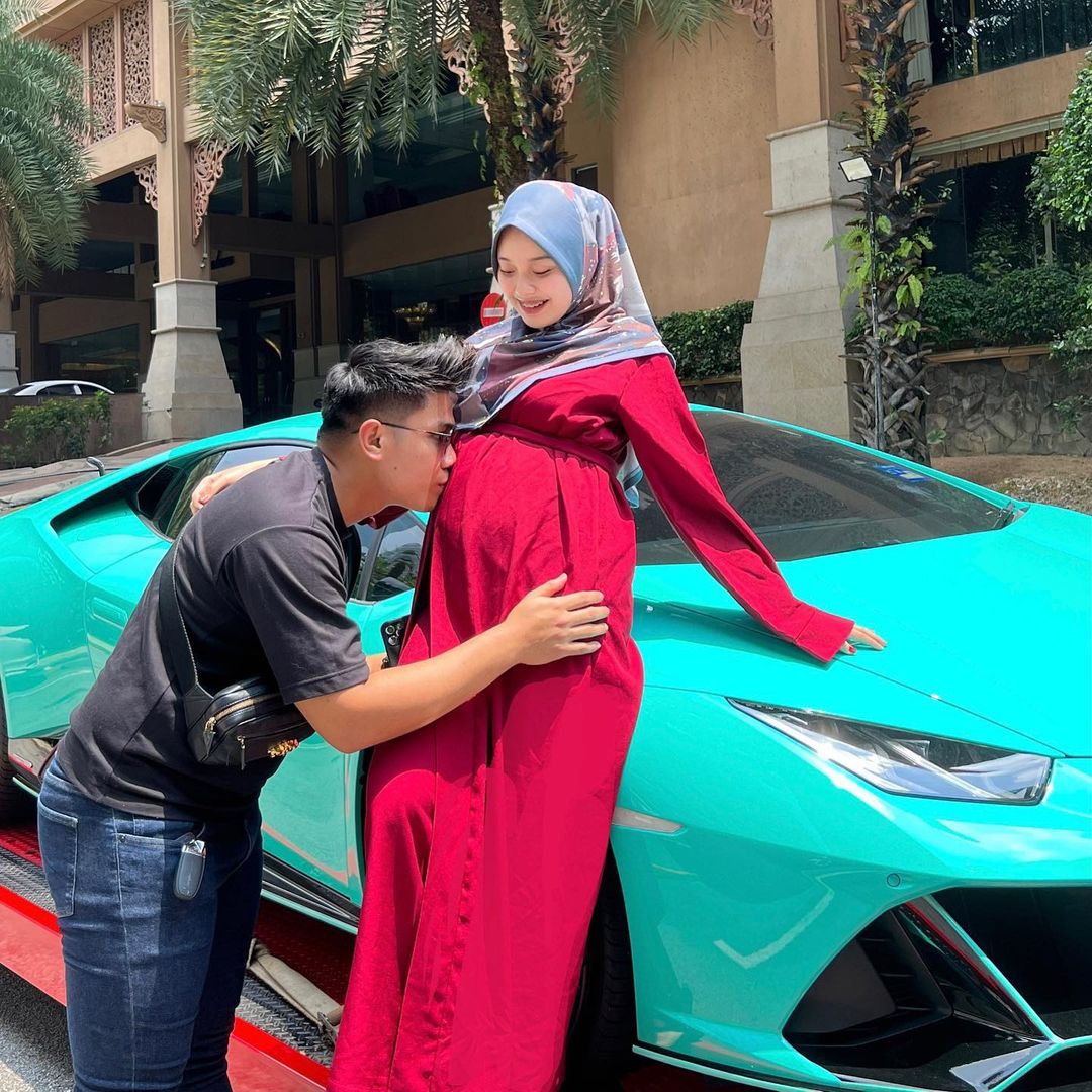 The happy couple posing in front of their new Lamborghini. Source: ayunieso_