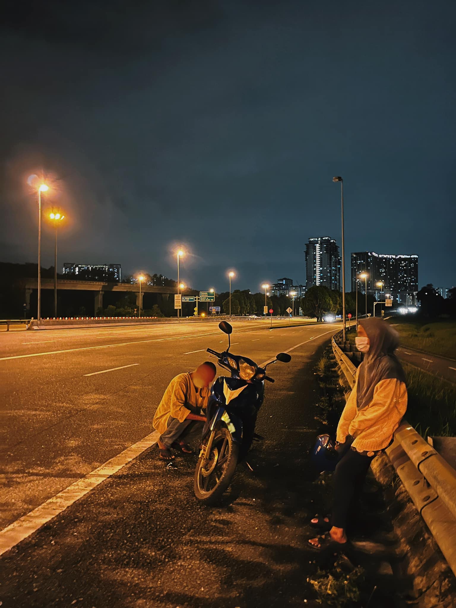 Both father and daughter had been left stranded on the highway when their motorbike ran out of motor oil. Source: Alessandra Ng
