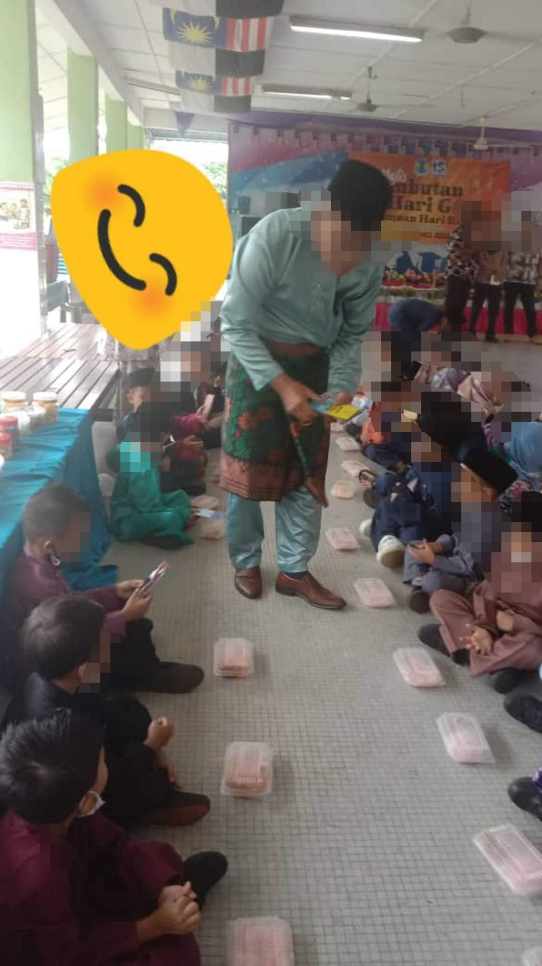 Students from a local school were allegedly seen dining on the floor, while teachers ate at banquet tables. Image credit: Mohd Fadli Salleh