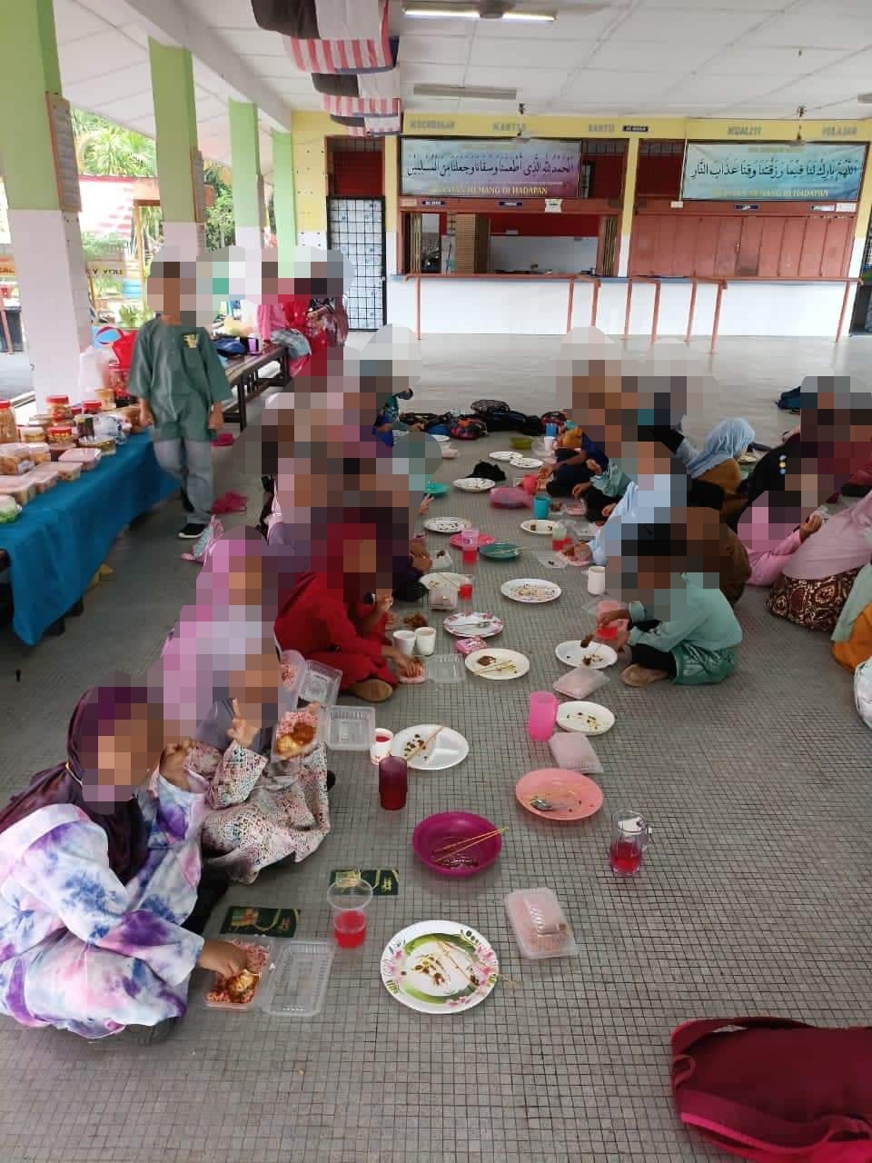Students from a local school were allegedly seen dining on the floor, while teachers ate at banquet tables. Image credit: Mohd Fadli Salleh