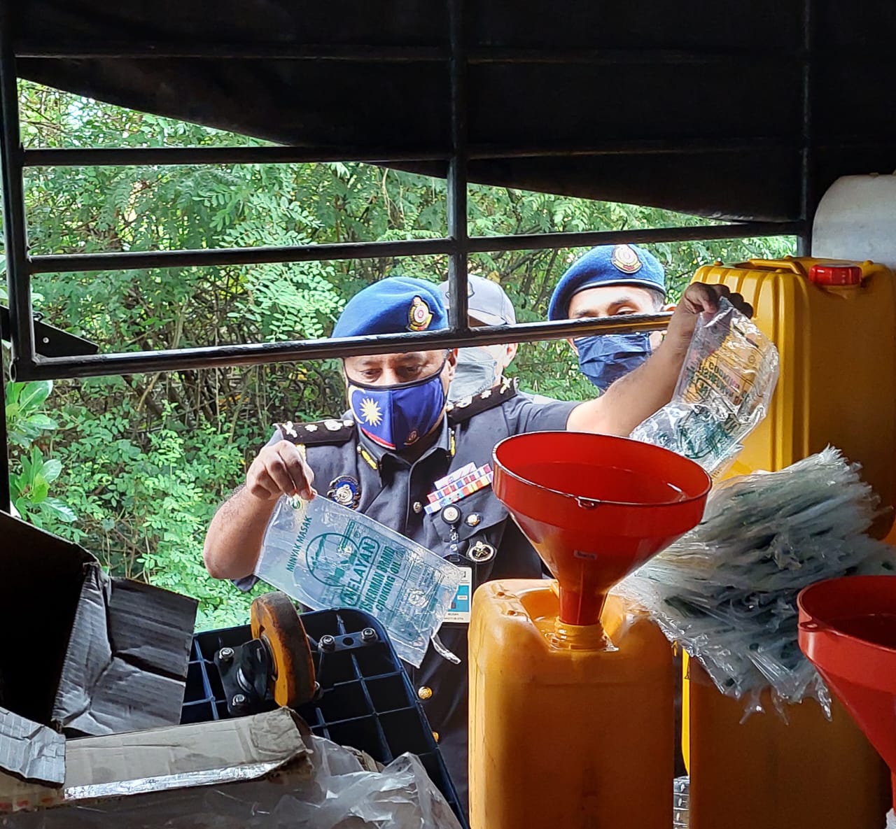 A Penang man was found to be smuggling subdisided cooking oil, while mixing it with prayer oil to be sold to consumers. Image credit: Utusan Digital