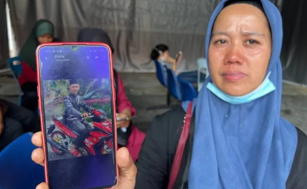 Mother to 22-year-old Mohd Shazwan Hakim Mohd Abdul Sani, Mashitah Md Isa, showing a photo of her son who died in the crash. Image credit: NST