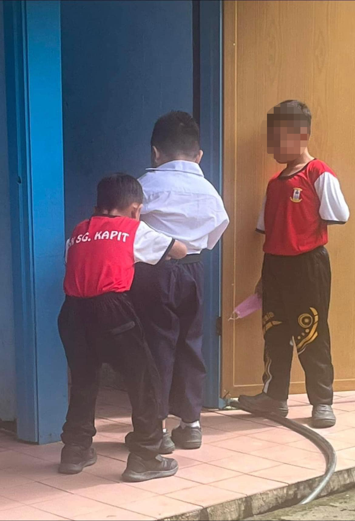 Two young boys were seen helping their friend with special needs to use the toilet. Image credit: Sylvester Ronny Pulene