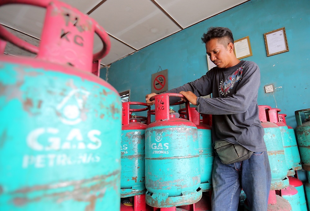 A man moving gas cylinder tanks. 