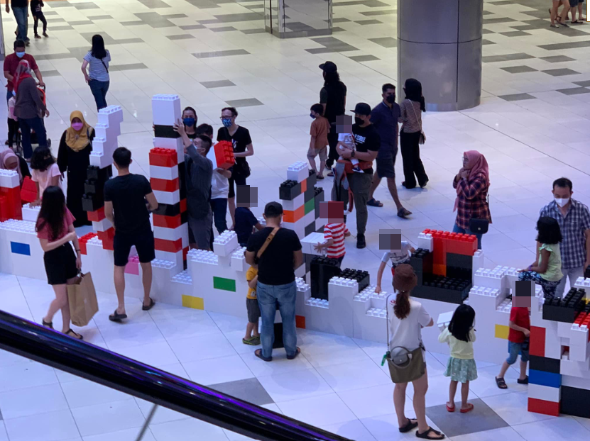 Mall visitors were seen dismantling a LEGO display despite a sign telling them not to do so. Image credit: Sin Chew Daily
