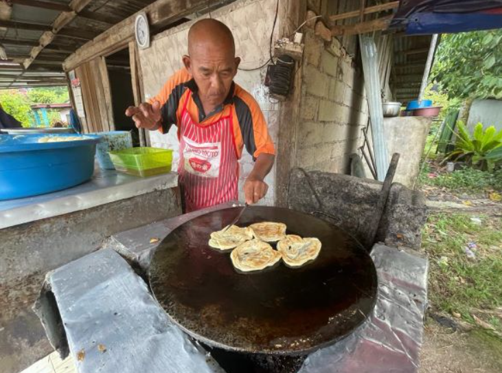 A Kelantan vendor strives to keep the prices of his roti canai at 50 sen a piece. Image credit: Utusan Malaysia