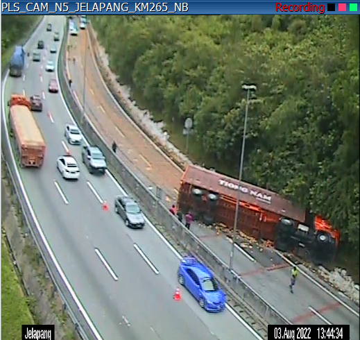 Trailer carrying sardines overturns at KM265.9 of the North-South Expressway. Image credit: LLMInfotrafik