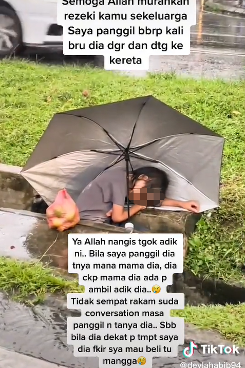 A netizen recently encountered a young girl in Sabah who fell asleep in a drain while selling mangoes by the road. Image credit: deylahabib94