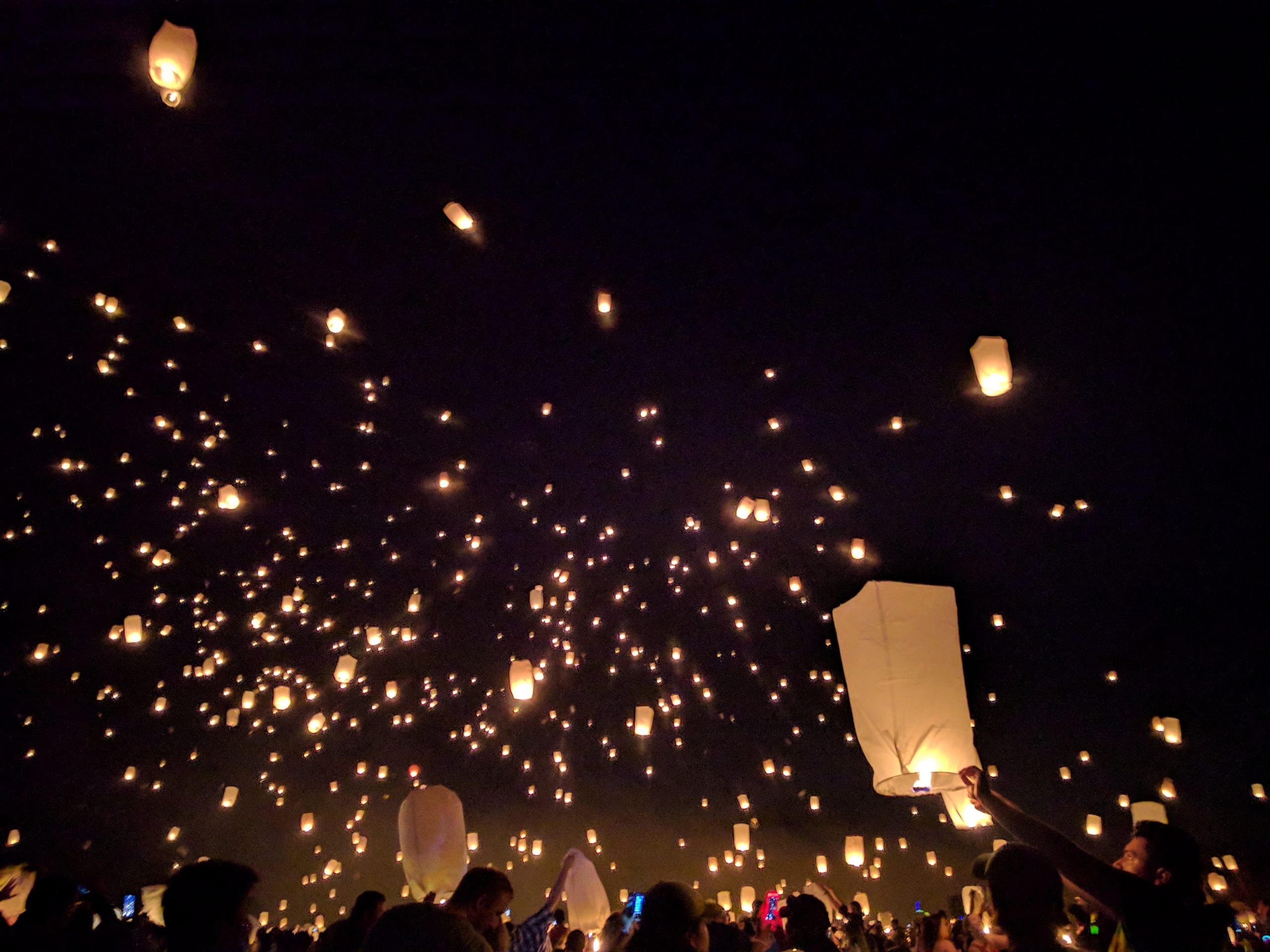 Sky lanterns lighting up a night sky. Image credit: Lacey Day via Pexels