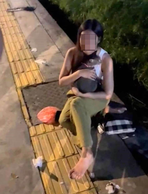 She was later seen on the sidewalk comforting her pet cat. Image credit: Sin Chew Daily