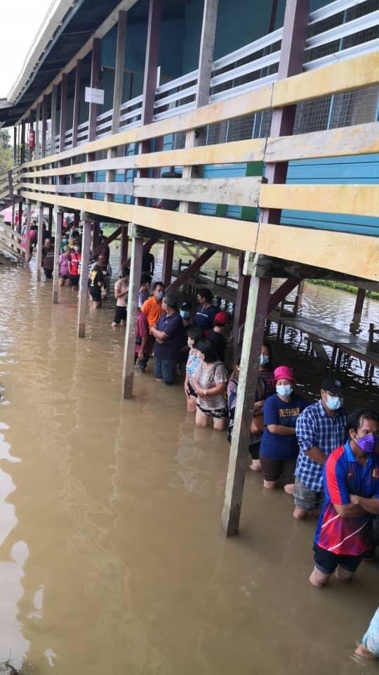 Voters in the Baram district seen queueing up while standing in knee-deep floodwaters to vote for GE15. Image credit: Samudera.my