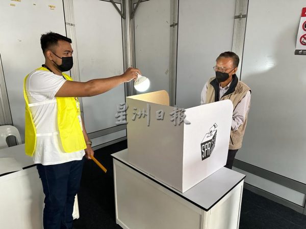 Voters had to cast their ballots with the help of portable lightbulbs. Image credit: Sin Chew Daily