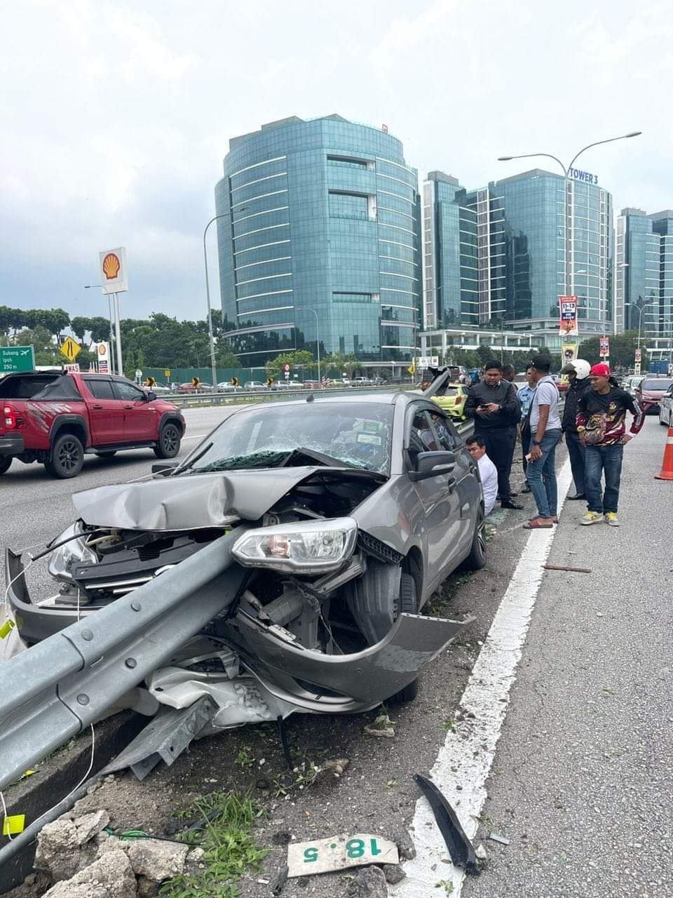 A freak accident along Federal Highway led to a metal highway guardrail piercing through a Proton Saga. Image credit: 我们是马来西亚人 We are Malaysians
